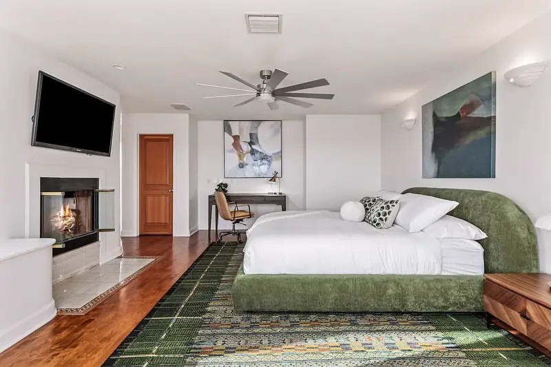 Green bed, white walls, wooden floor