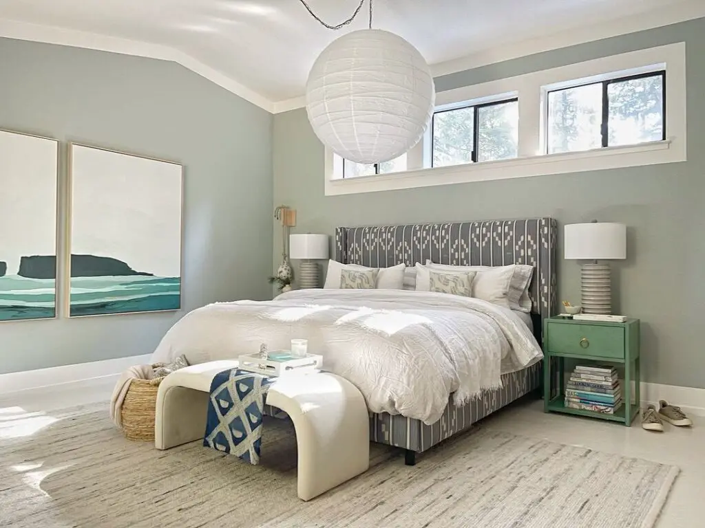 Coastal-themed bedroom with green walls and ocean artwork
