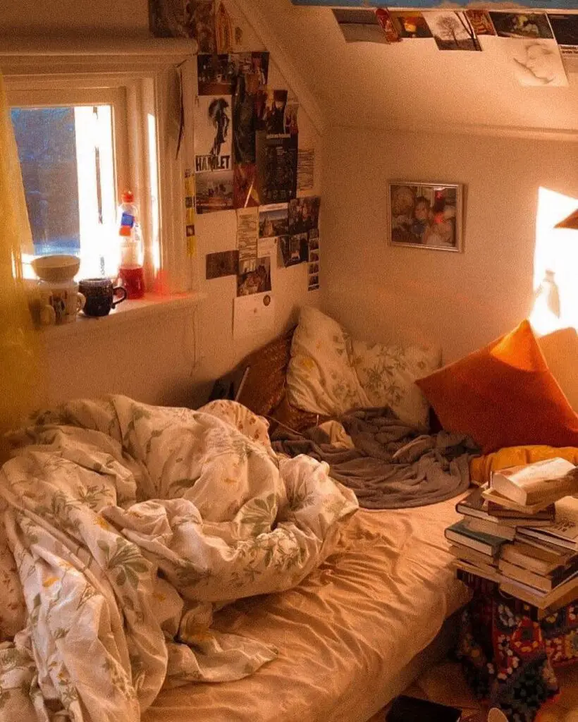 Messy bed with books and wall decorations in warm lighting