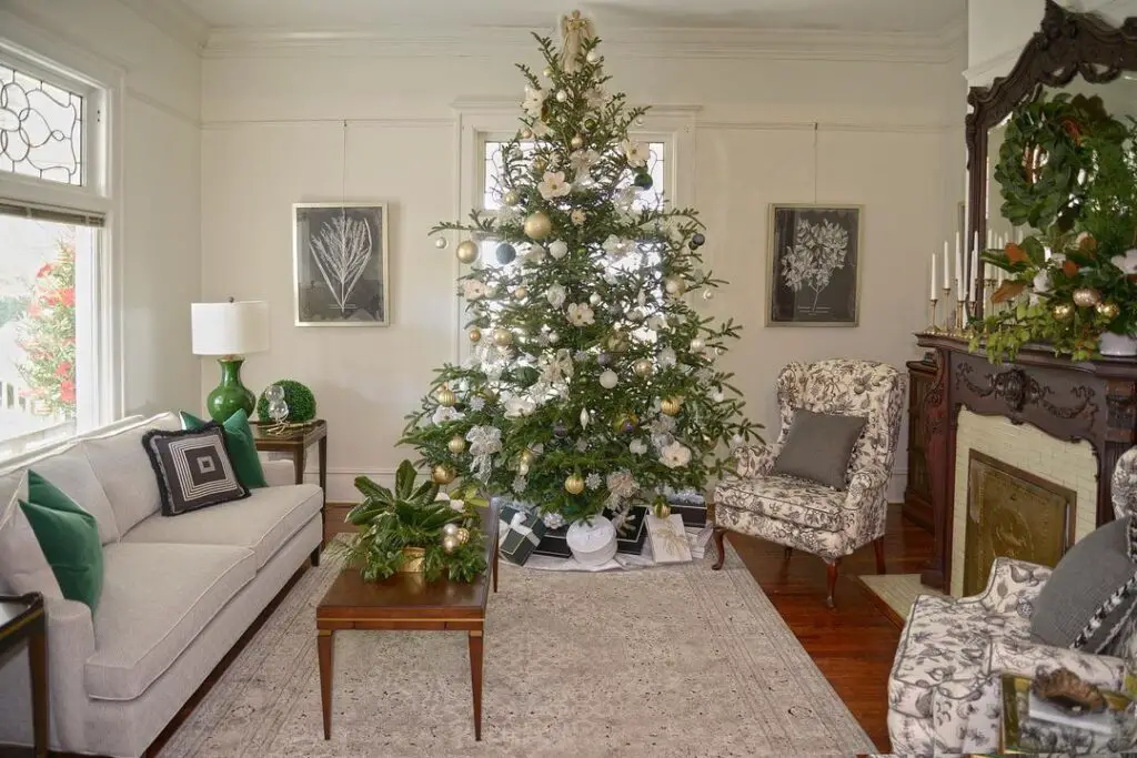 Living room with floral-themed Christmas tree and fireplace.