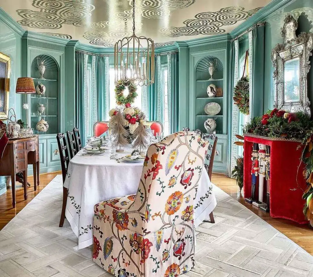 A beautifully decorated seafoam green dining room with an ornate table setting, built-in cabinets