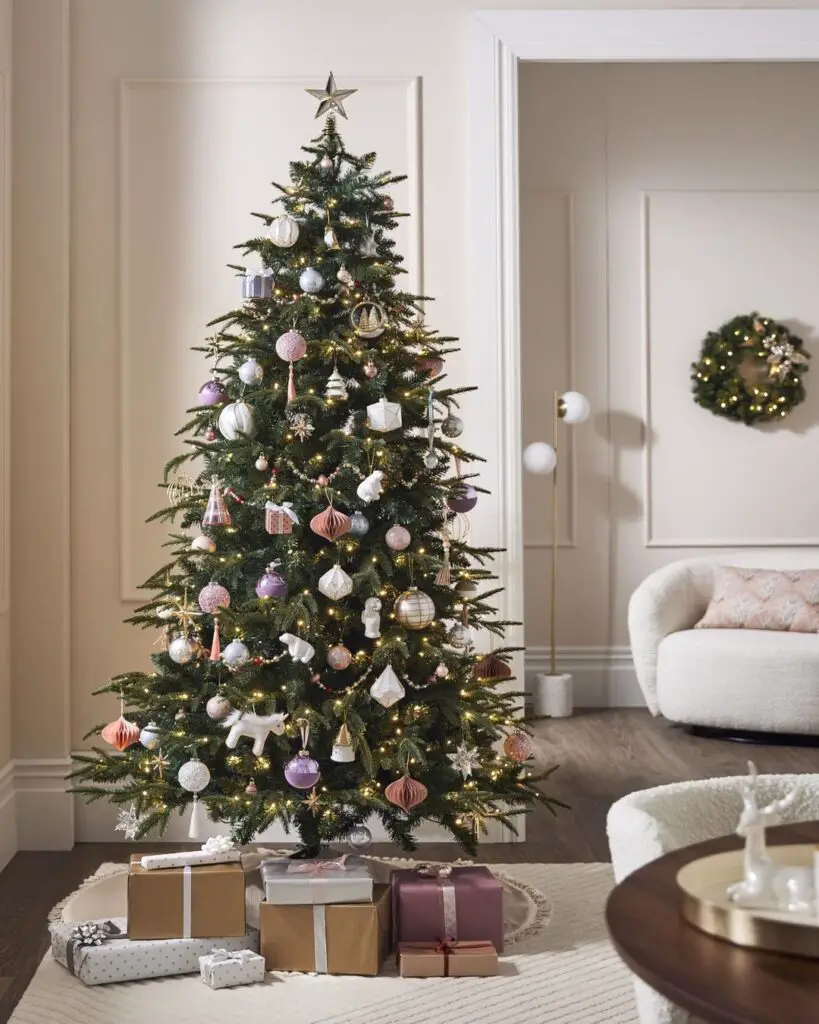 A stylishly decorated pastel-toned Christmas tree with ornaments and presents.