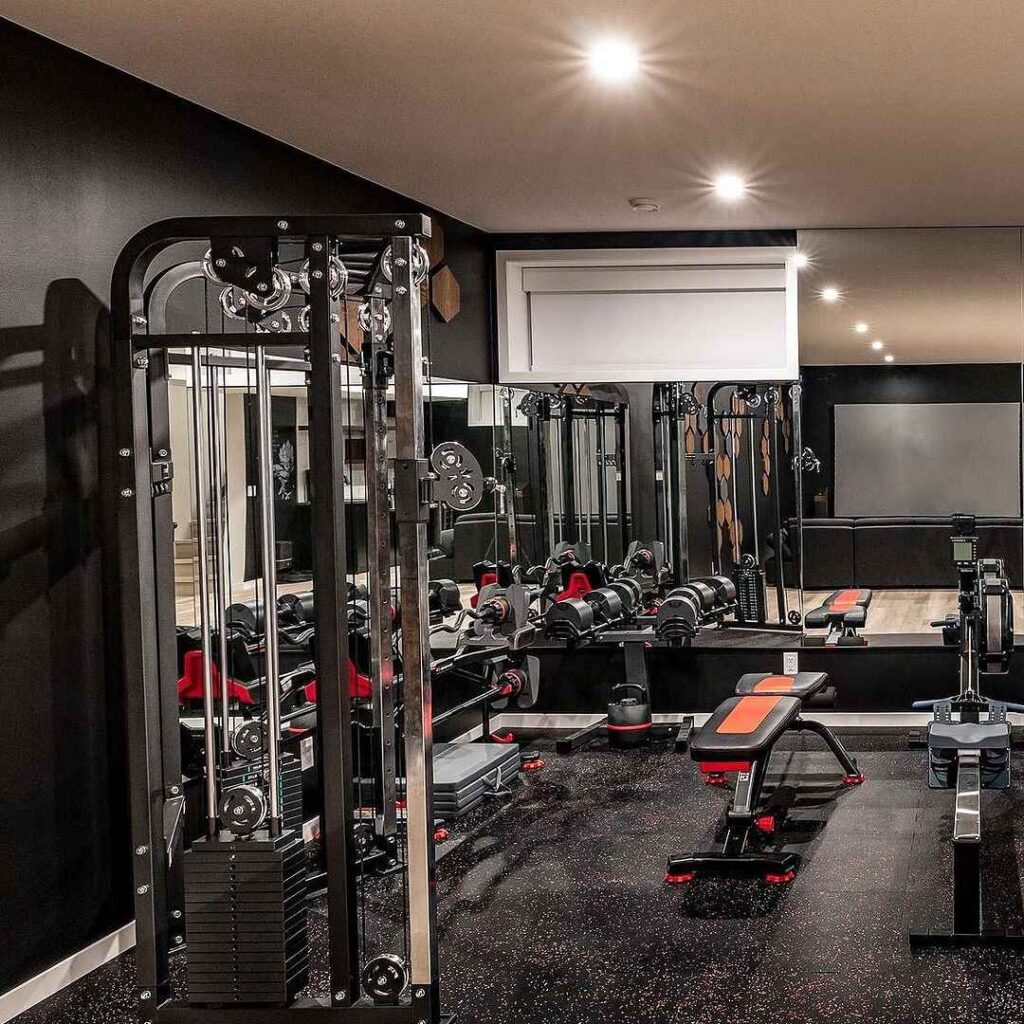 Fully equipped dark-themed home gym with machines