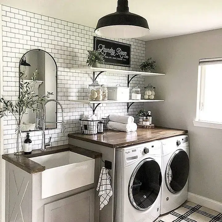 Farmhouse style laundry room with subway tiles apron sink and modern appliancesShare