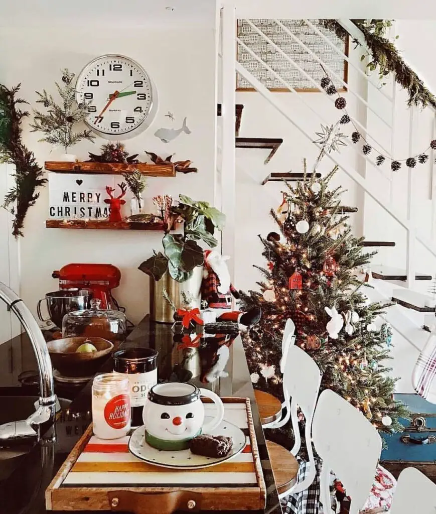 Decorated Christmas tree surrounded by holiday decorations and cocoa mug with treats.