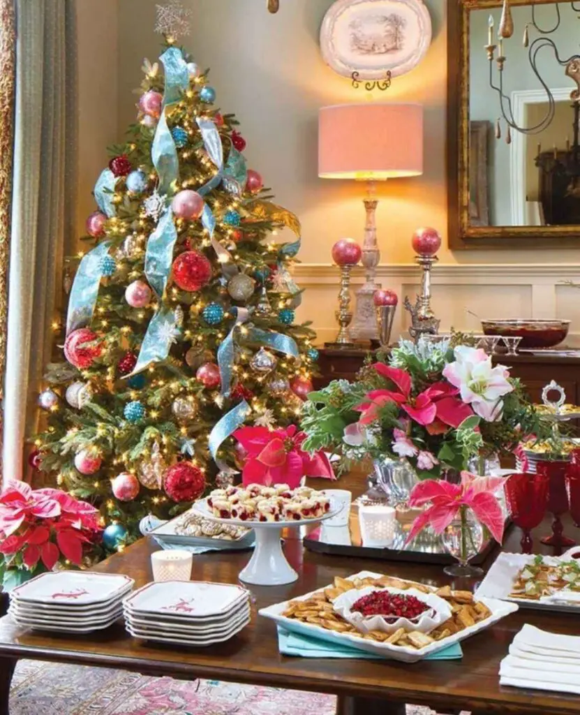 A living room with a colorfully decorated Christmas tree, a table set with holiday treats