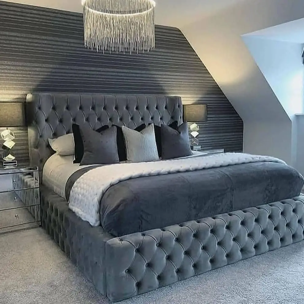 Modern bedroom with gray tufted bed and striped walls