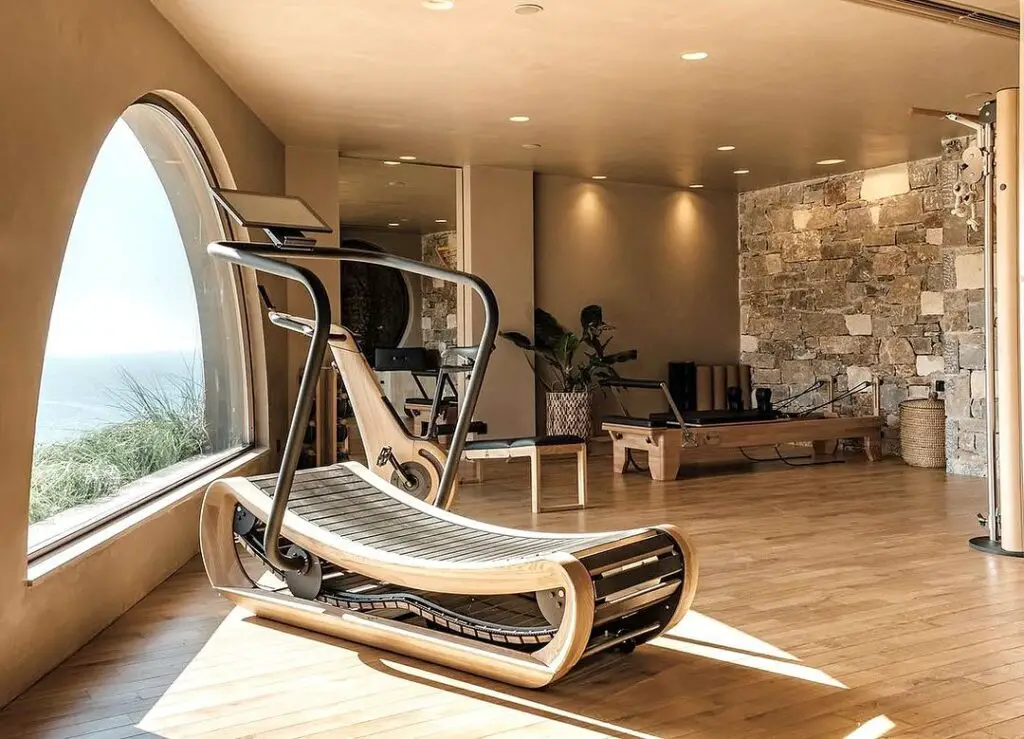 Luxurious home gym with ocean view and wooden treadmill