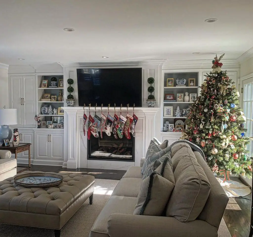Living room with Christmas tree, fireplace, and tufted sofas.