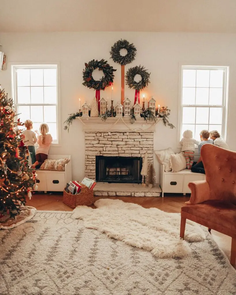 Cozy living room with decorated fireplace, Christmas tree, and children by windows