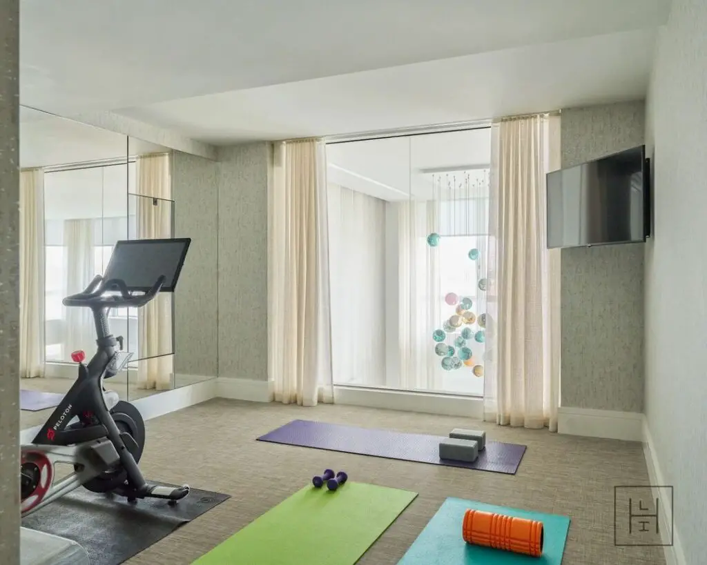 Bright home gym with spin bike and yoga mats