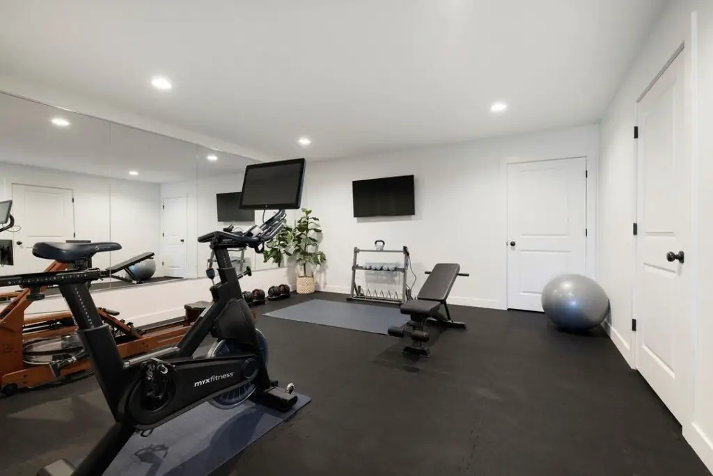 Modern home gym with exercise equipment and mirrored wall