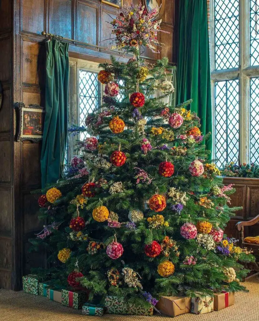 A lavishly decorated Christmas tree adorned with lifelike floral ornaments resembling roses