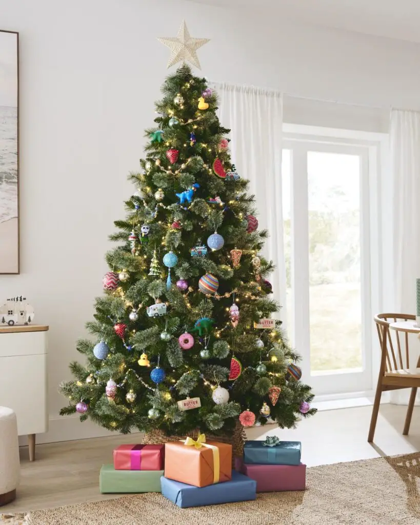 Colorfully decorated Christmas tree with presents underneath in living room.
