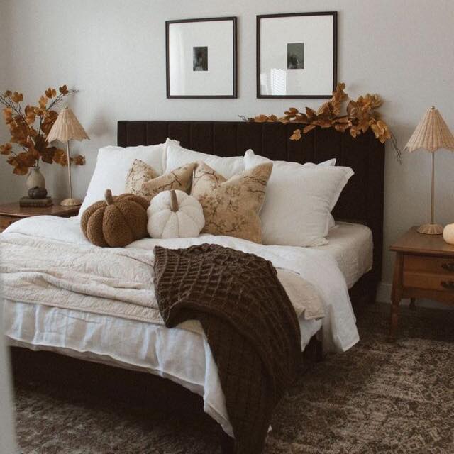 Bedroom with autumn decor white bedding and fabric pumpkins