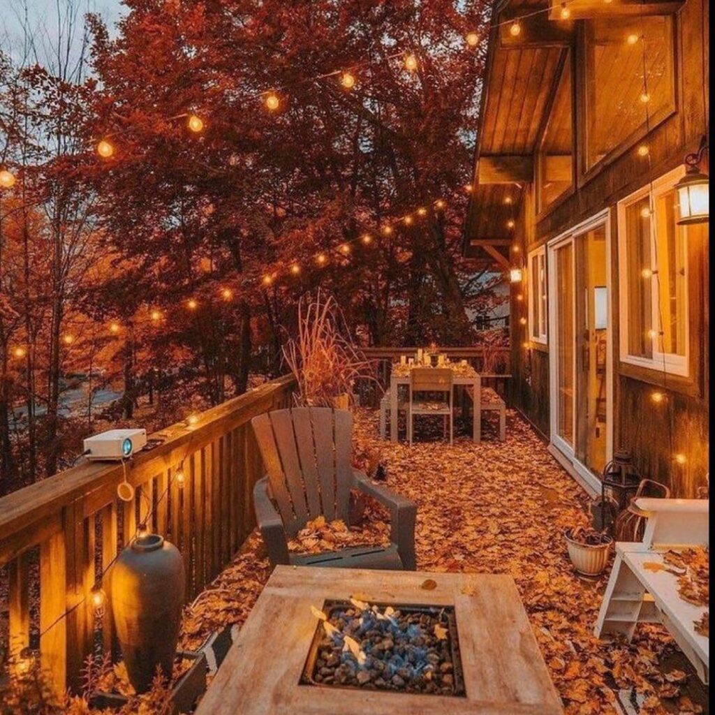 Cozy cabin deck with autumn leaves and string lights