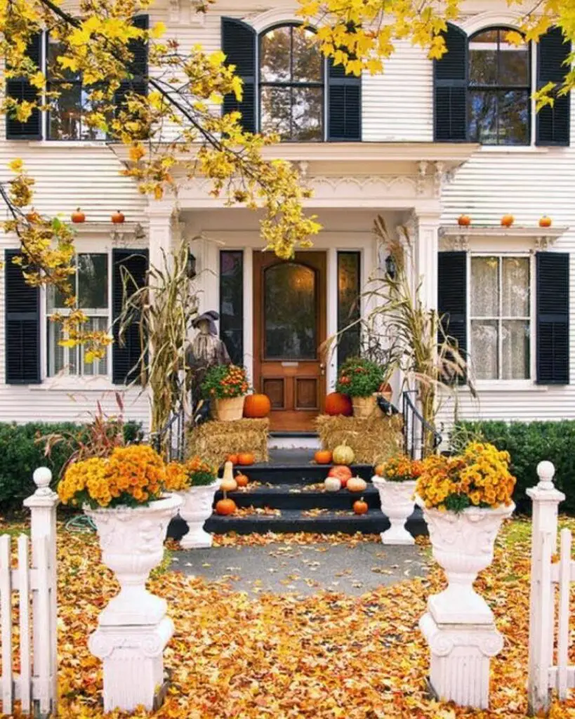 White house with fall decorations and yellow leaves