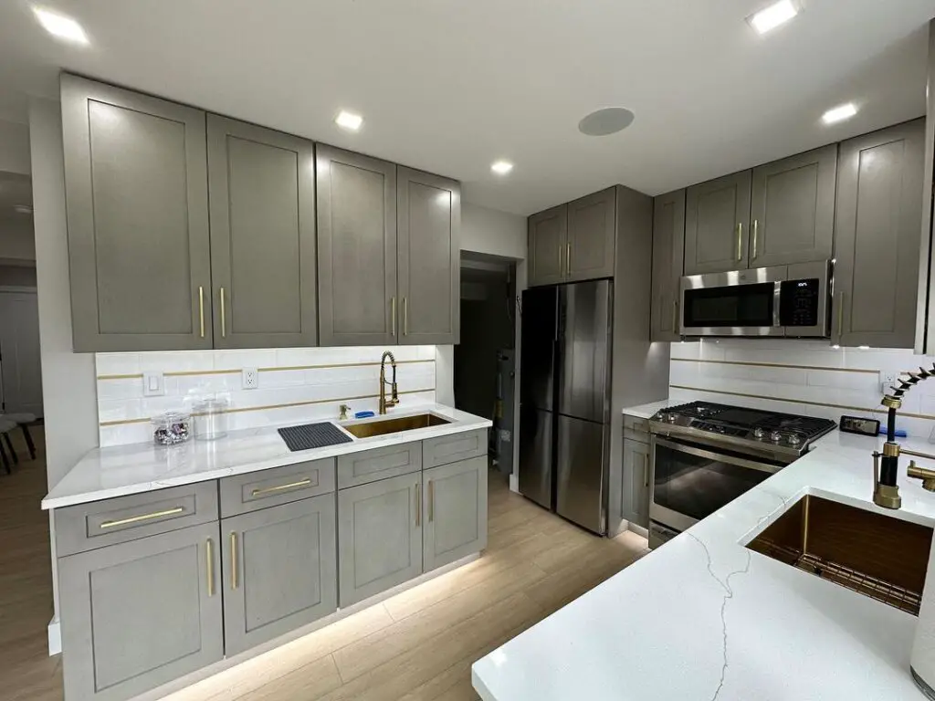 Contemporary kitchen with warm gray cabinets, quartz counters, waterfall island.