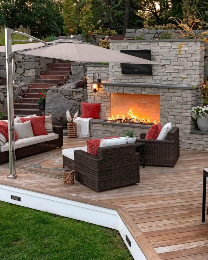 Outdoor patio with stone fireplace and comfortable seating on wooden deck