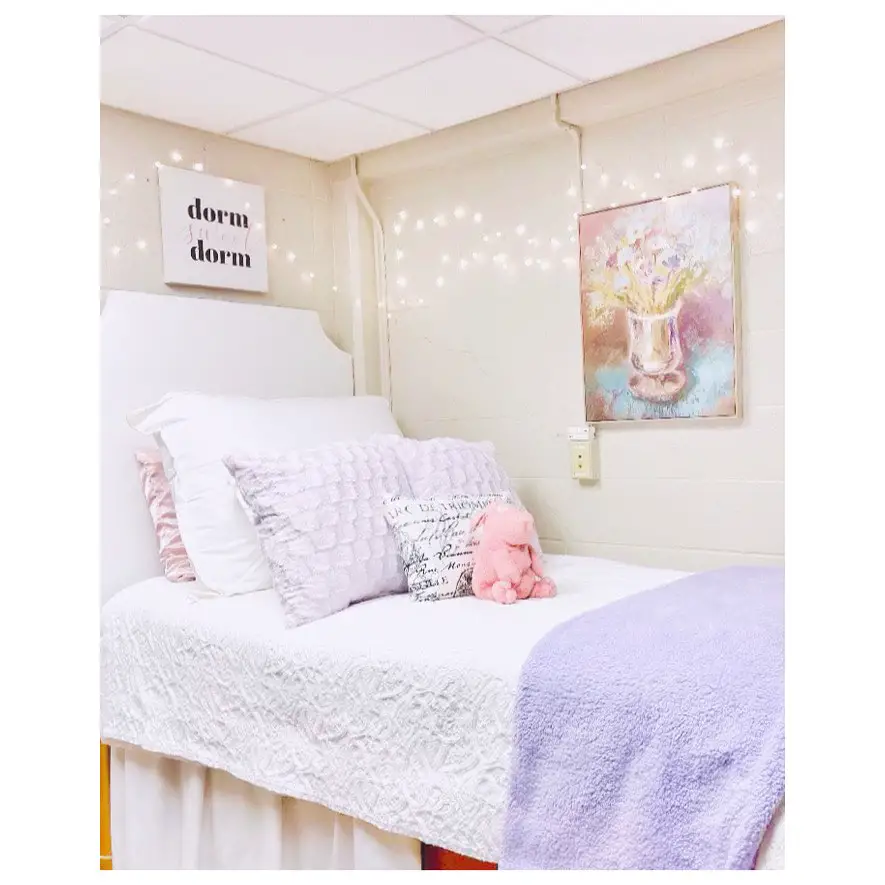 Cozy dorm bed with fairy lights and pastel decor