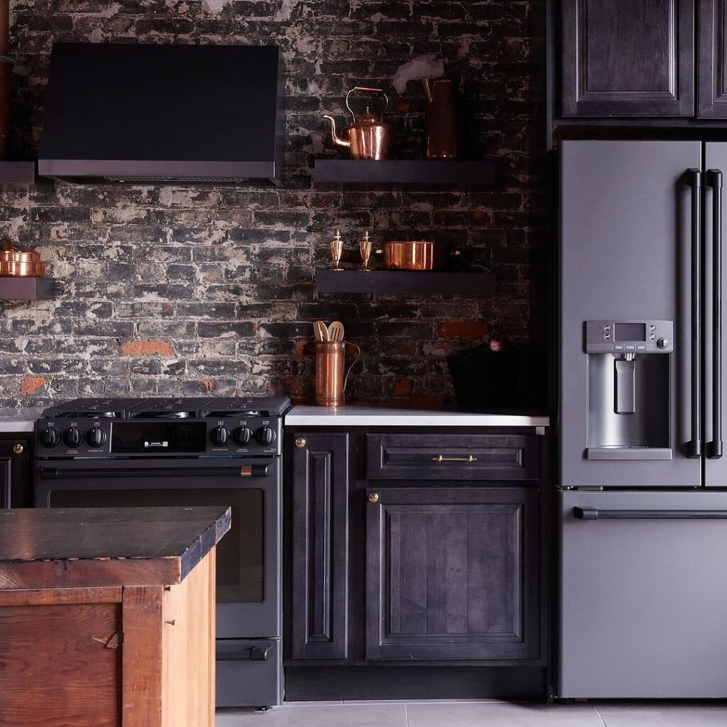 Dark kitchen with brick wall and copper accents