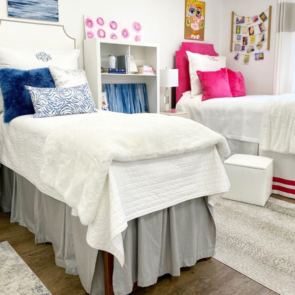 White bedding with bright pink and blue accents, patterned artwork.