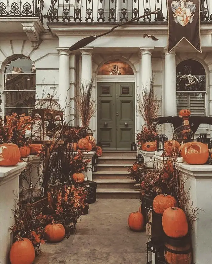 Townhouse entrance decorated with pumpkins and fall foliage