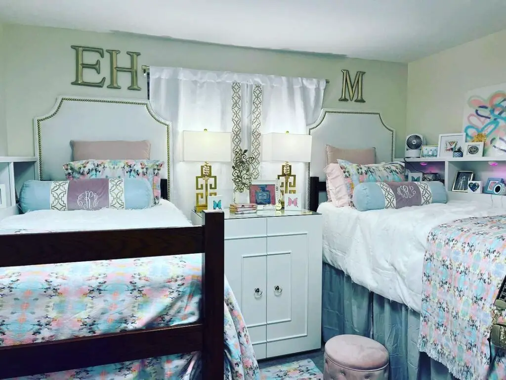 Two twin beds in floral bedding, monogrammed pillows, matching headboards