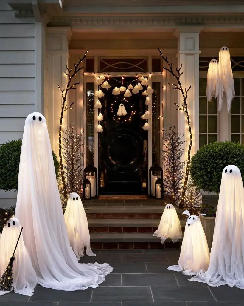 Porch decorated with glowing ghost figures and twinkling lights
