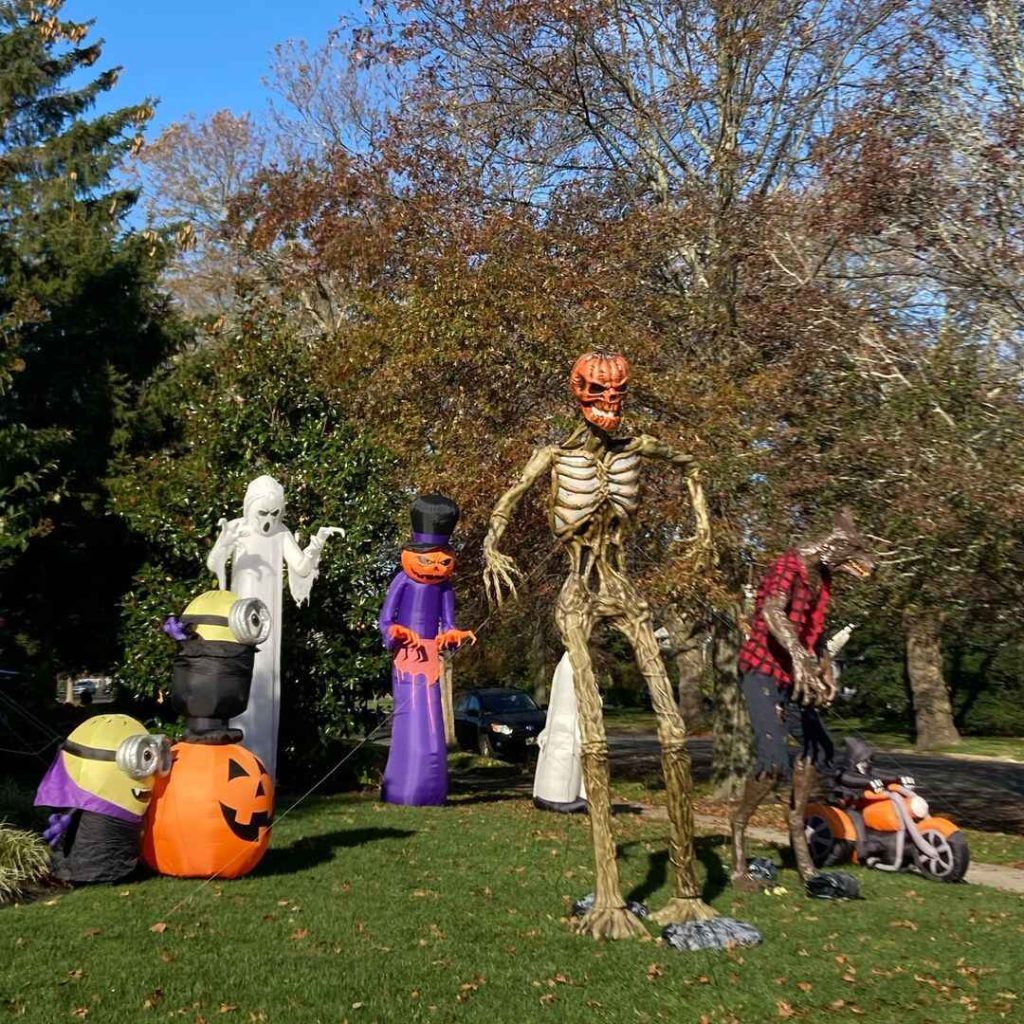 Front yard filled with Halloween inflatables including skeleton ghost and Minions
