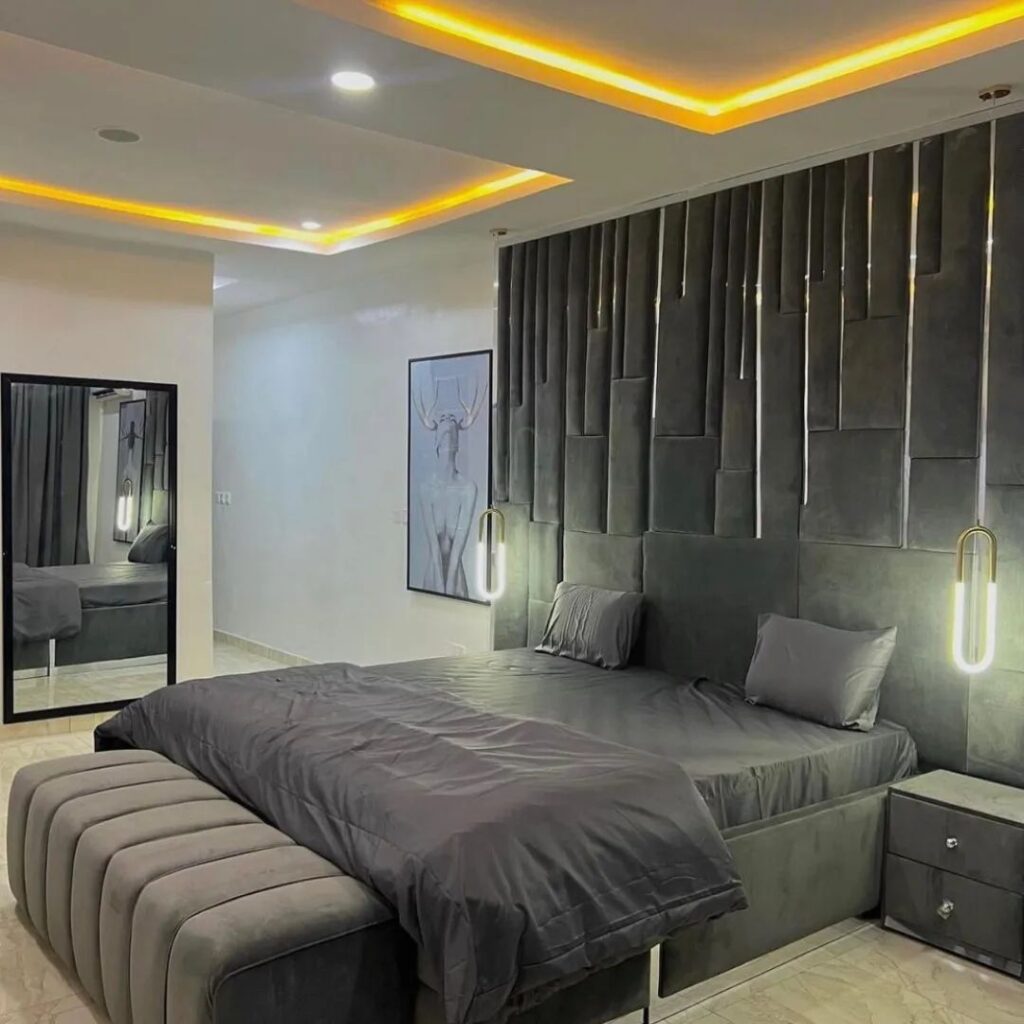 Modern bedroom with gray decor and yellow ceiling lights