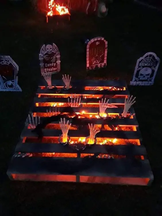 Wooden pallet with fire effect and skeleton hands reaching out