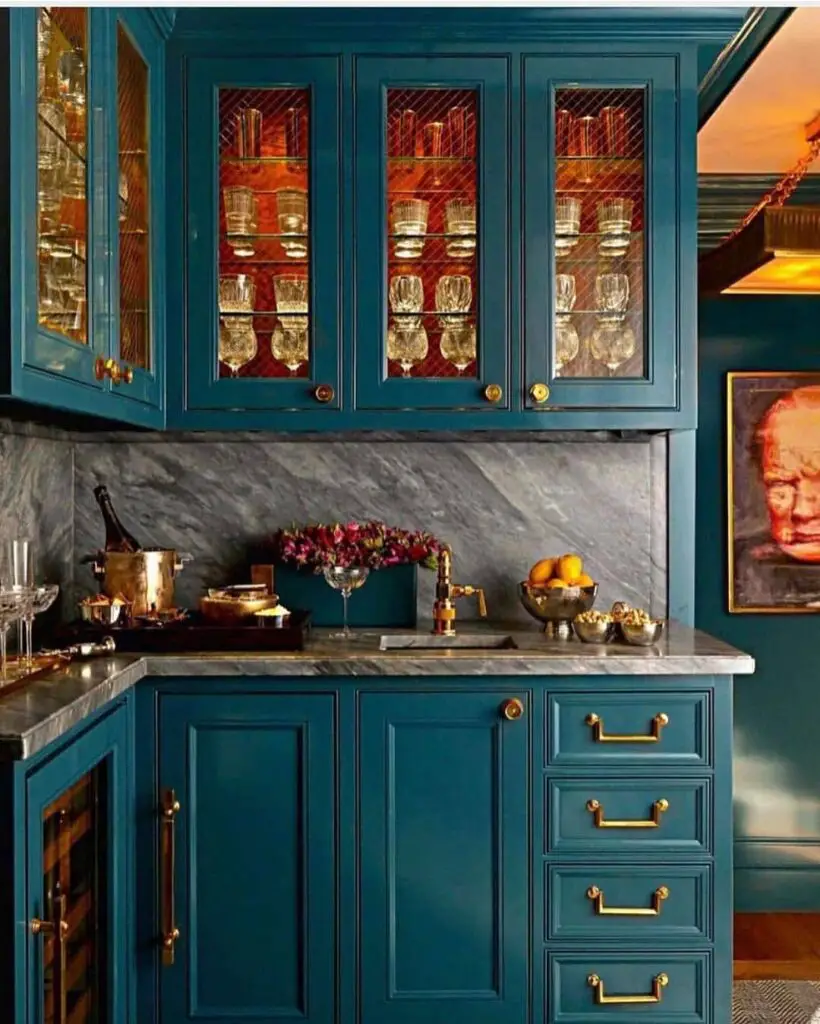 Teal bar cabinet with glass doors displaying crystal stemware