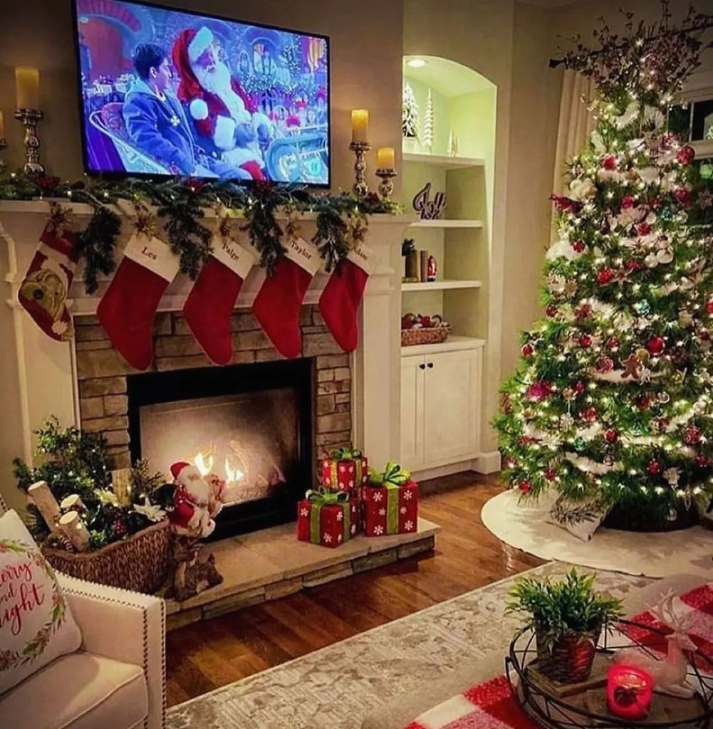 Christmas living room with decorated tree fireplace and holiday movie on TV