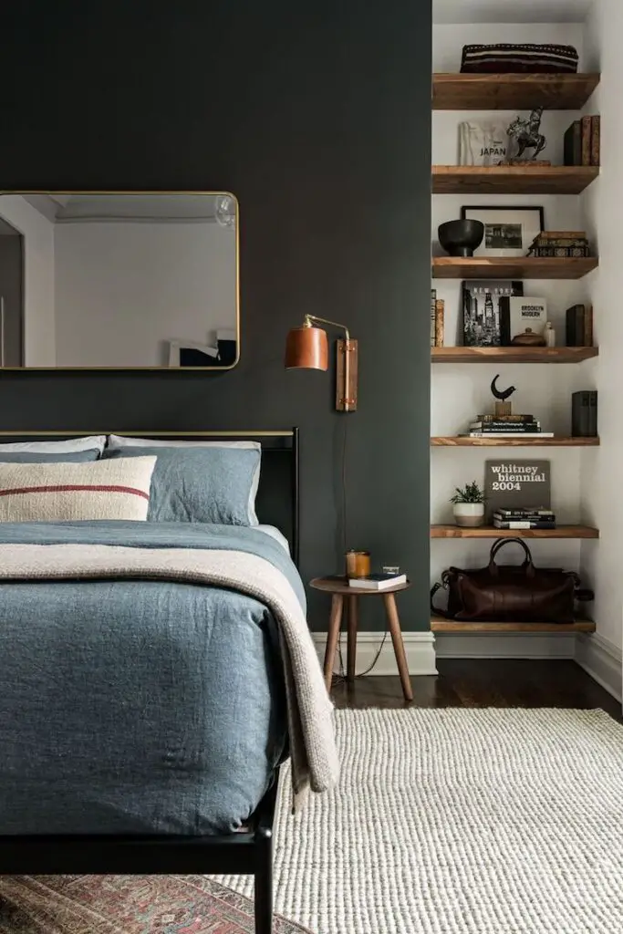 Dark bedroom with blue bedding and wooden bookshelves