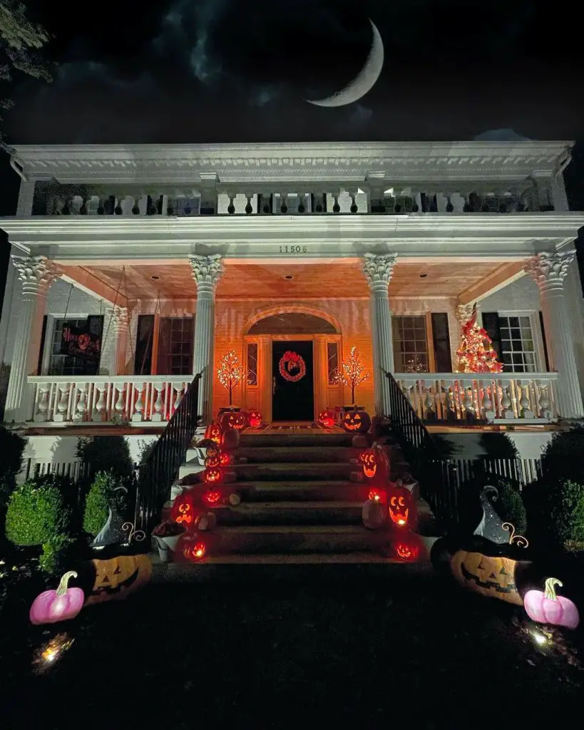 Elegant house decorated for Halloween with lit pumpkins and crescent moon