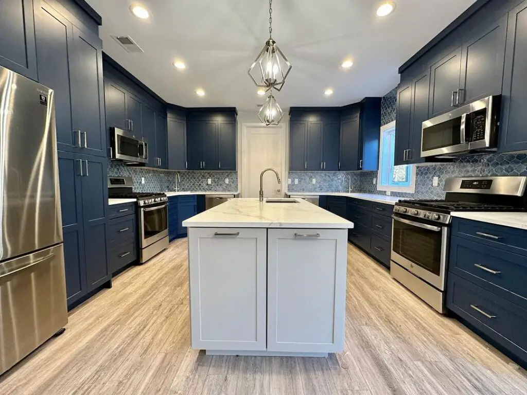 Navy kitchen with white island and steel appliances
