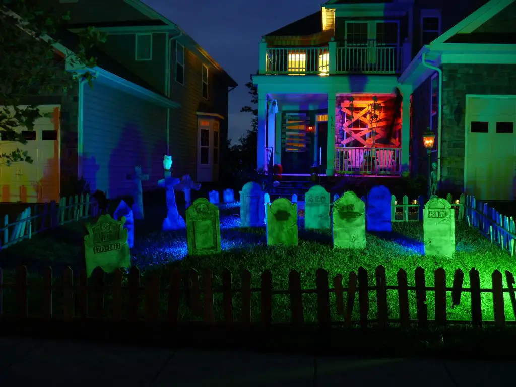 Colorfully lit Halloween graveyard decorations in yard