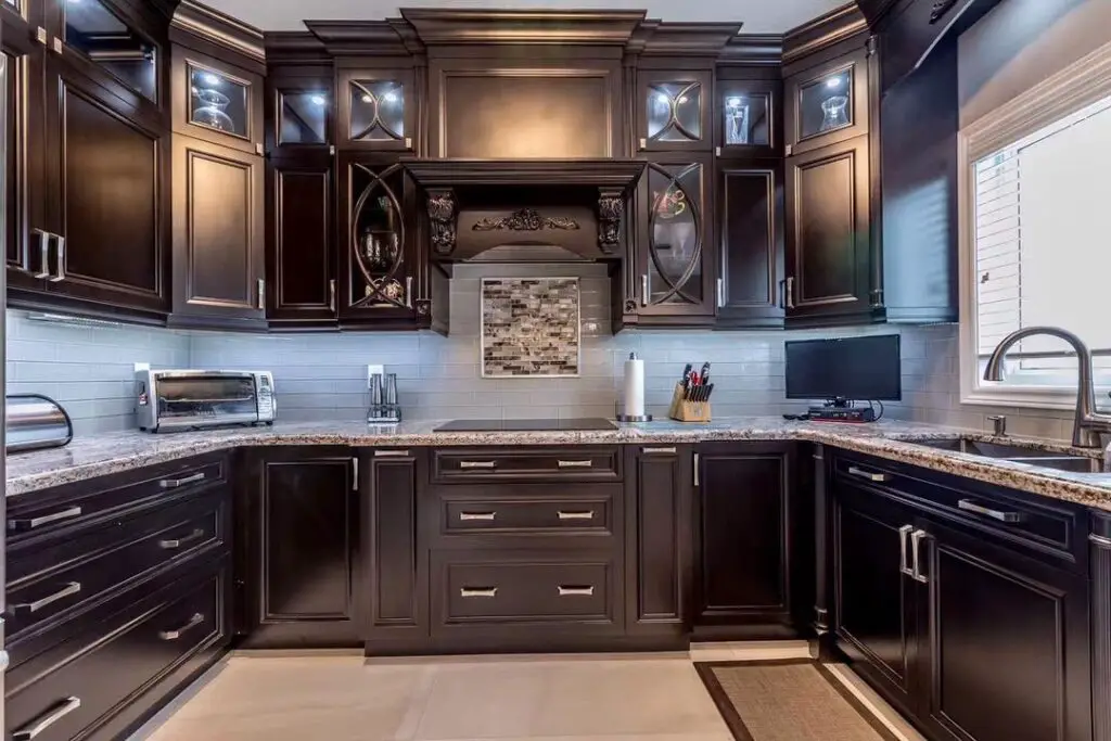 Luxurious dark wood kitchen with ornate cabinets and granite countertops