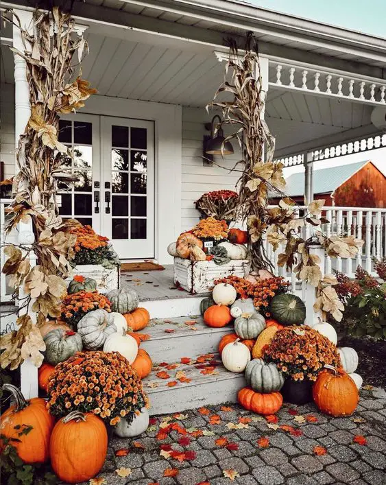 Pumpkin-adorned farmhouse porch with cornstalks