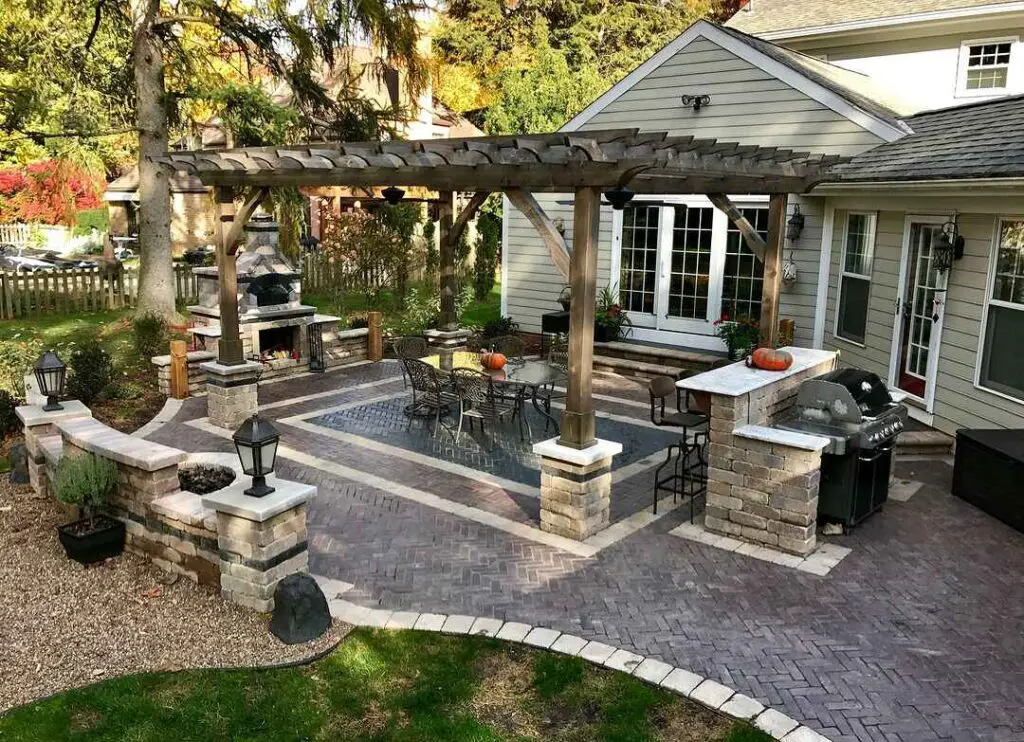 Cozy backyard patio with pergola kitchen and seating areas
