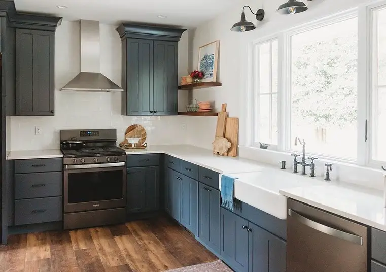 Rustic kitchen with blue cabinets, wood floors, farmhouse decor.