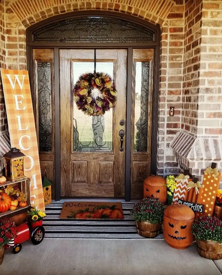 Wooden door with fall wreath pumpkins and harvest decorations