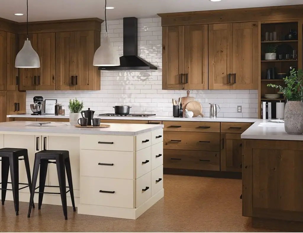 Rustic kitchen with alder cabinets, white island, and subway tile backsplash.