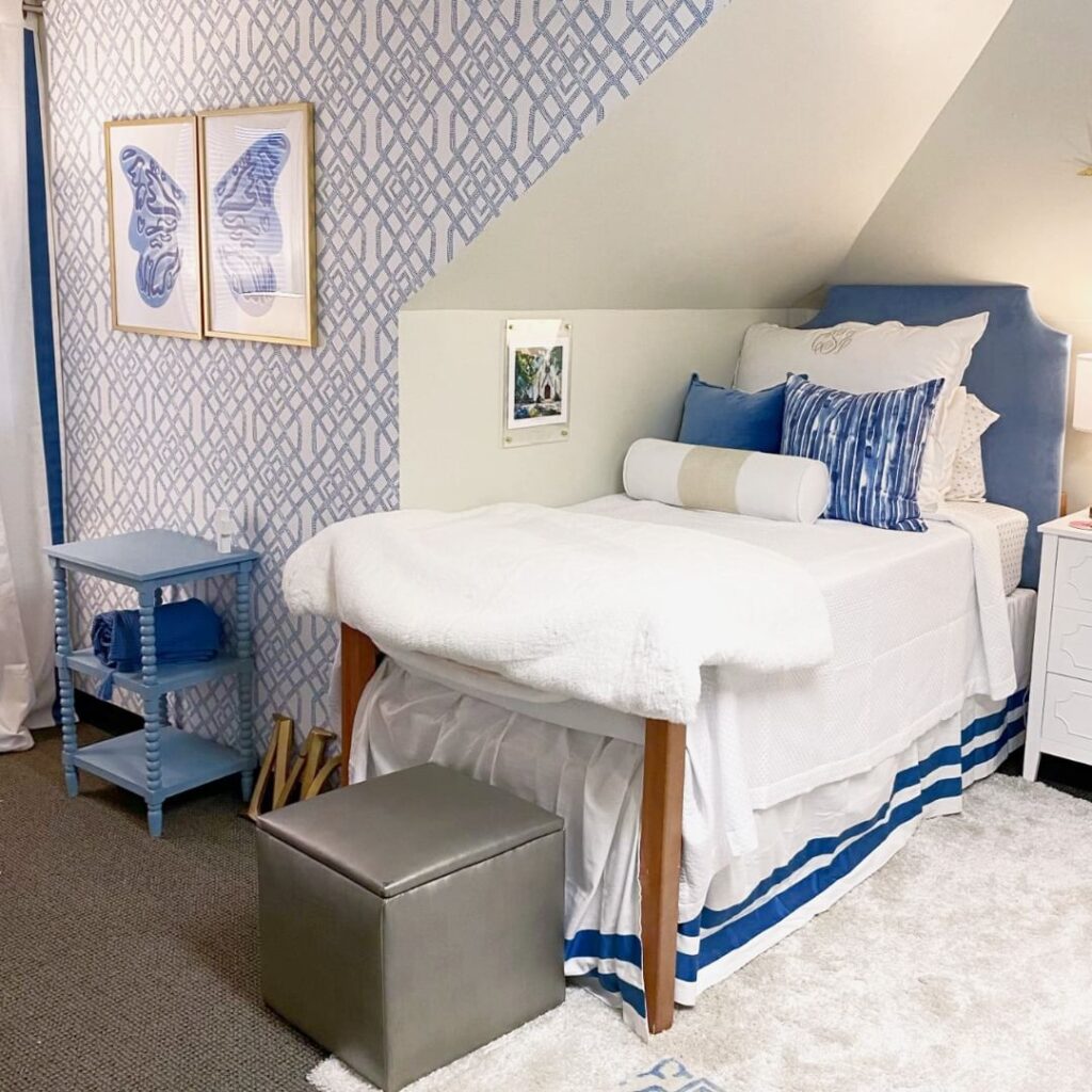Blue and white bedding, patterned accent wall, nautical decor.
