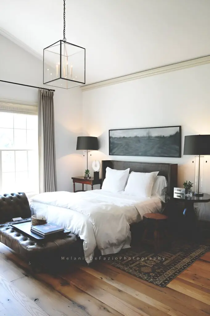 Minimalist bedroom with white bedding and dark accents