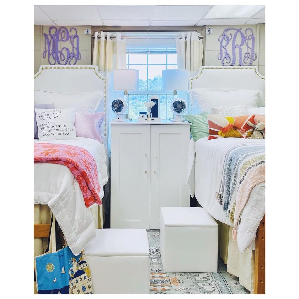 Twin beds with monogrammed wall hangings, storage cabinet, motivational decor.