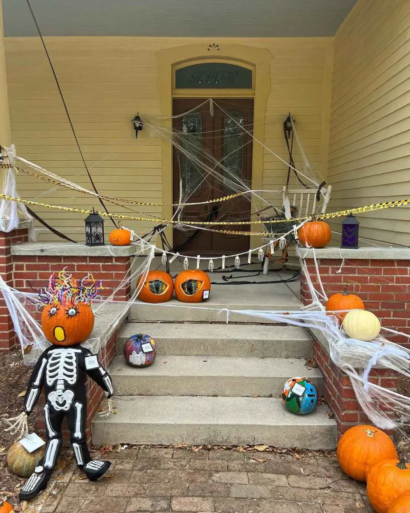 Halloween-decorated porch with pumpkins skeleton and cobwebs