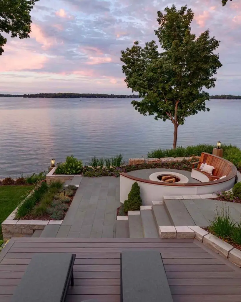 Lakeside patio with curved fire pit and sunset view