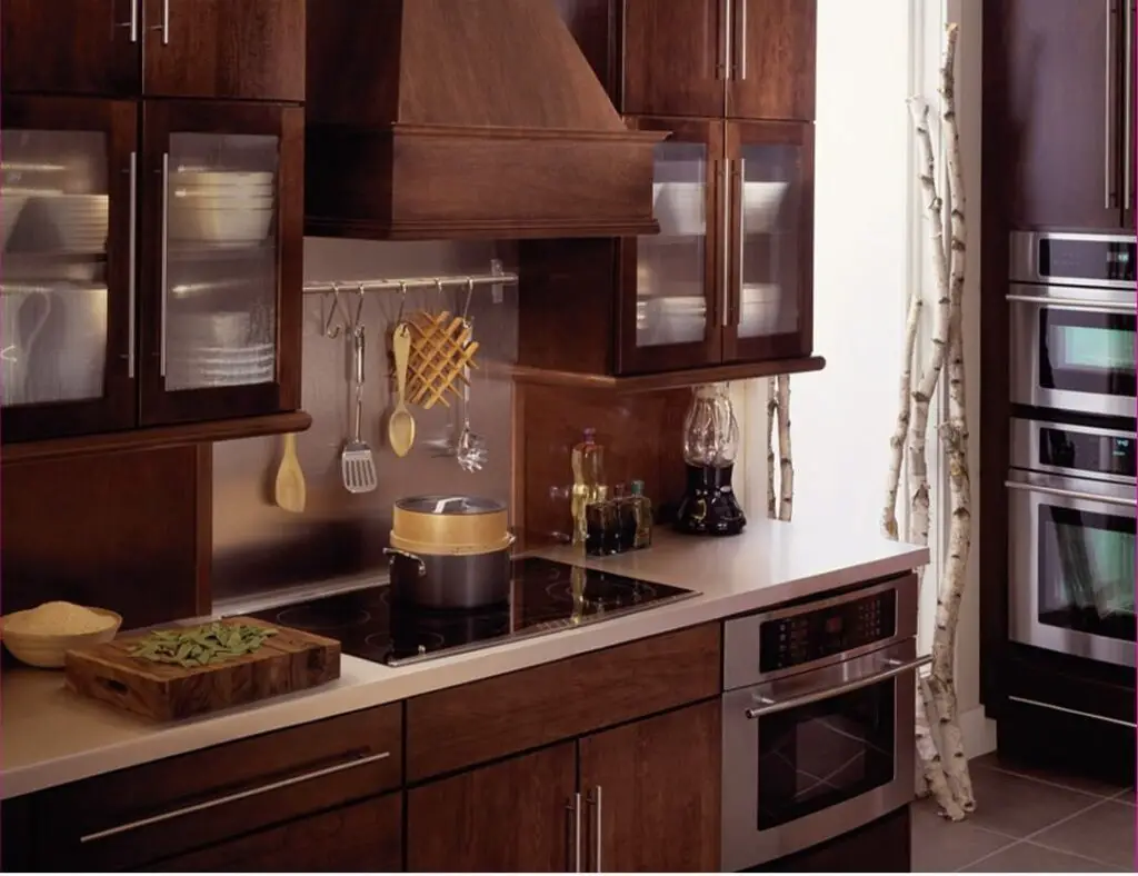 Elegant wood kitchen with double oven, pot rack, and wine display.